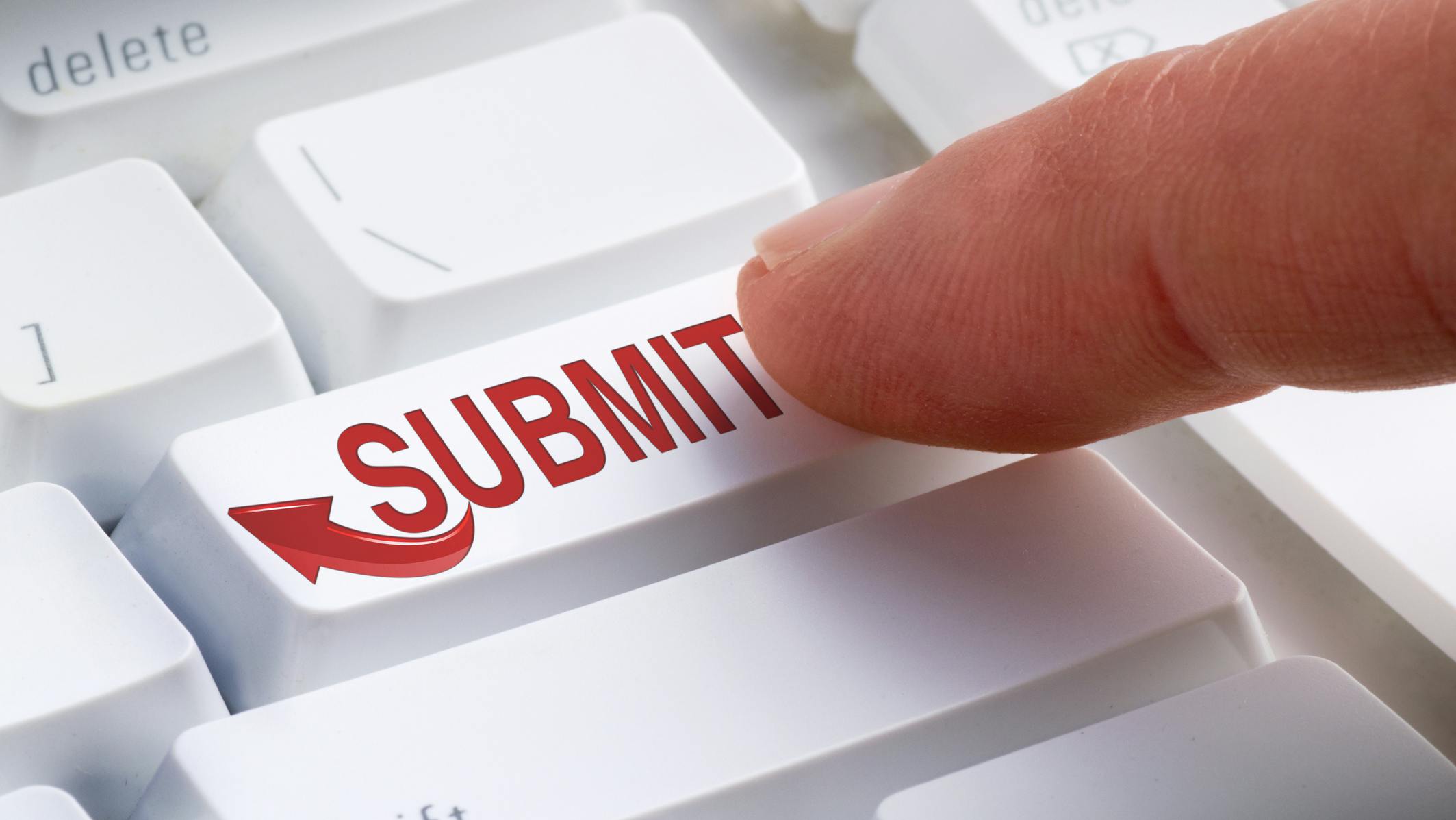 A white keyboard. A finger presses a key that says 'SUBMIT' in all red caps with a red arrow.