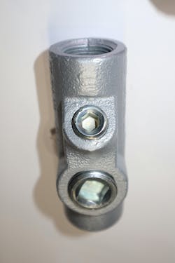 Photo 5a. Properly spacing conductors as they pass through the fitting, then pouring a sealing compound into the fitting, minimizes the passage of gases, vapors, and flames from one portion of a conduit system to another. This seal can be poured in a vertical position by removing the smaller plug. Photo 5a. Properly spacing conductors as they pass through the fitting, then pouring a sealing compound into the fitting, minimizes the passage of gases, vapors, and flames from one portion of a conduit system to another. This seal can be poured in a vertical position by removing the smaller plug.