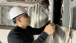 This apprentice is replacing a service panel on a job site. This apprentice is replacing a service panel on a job site.