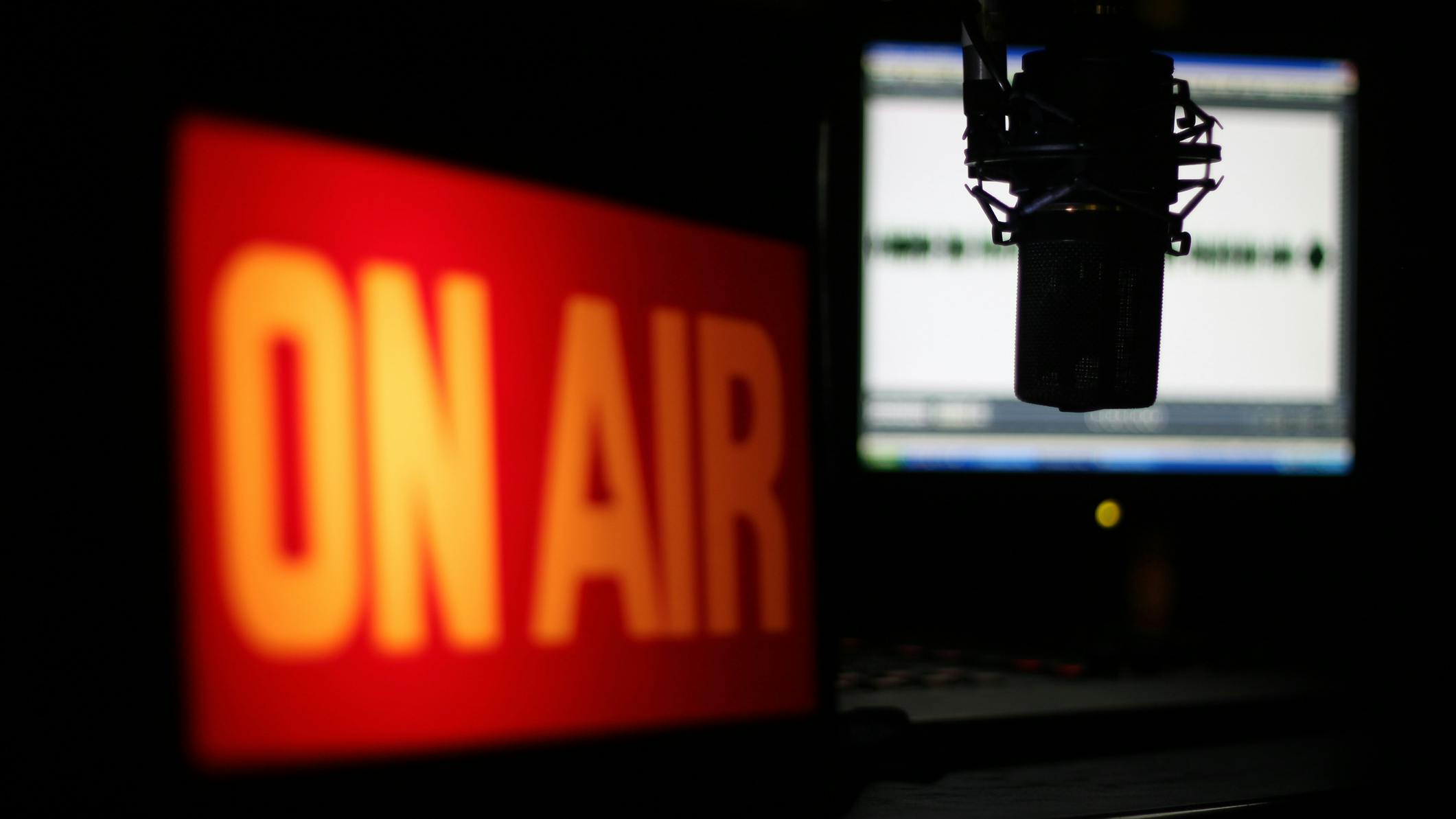 Microphone Interview. Radio studio with focus on the microphone and the interview about to unfold. Images features illuminated On Air sign and wave form monitor.