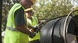 Two installers work with cable-in-conduit (CIC) on a job site Two installers work with cable-in-conduit (CIC) on a job site
