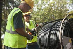 Two installers work with cable-in-conduit (CIC) on a job site Two installers work with cable-in-conduit (CIC) on a job site