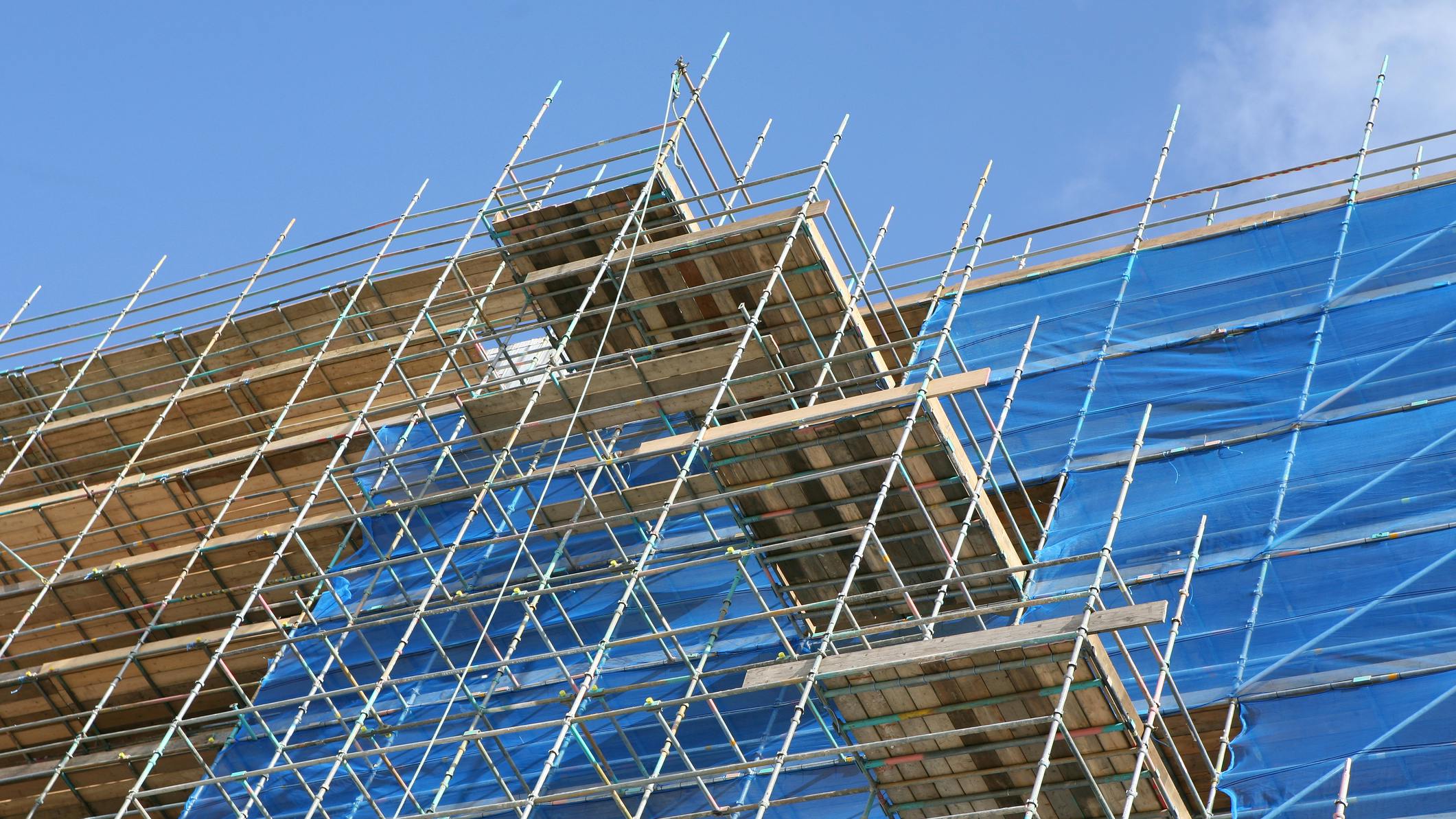 Modern apartment construction site with scaffolding an tarpaulin covering