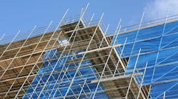 Modern apartment construction site with scaffolding an tarpaulin covering Modern apartment construction site with scaffolding an tarpaulin covering