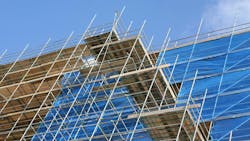 Modern apartment construction site with scaffolding an tarpaulin covering Modern apartment construction site with scaffolding an tarpaulin covering