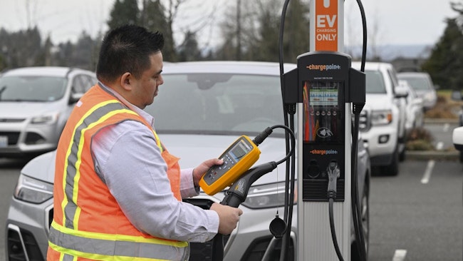 Employee performing maintenance work on an EV charging station.