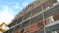 A building under construction with scaffolding around it A building under construction with scaffolding around it