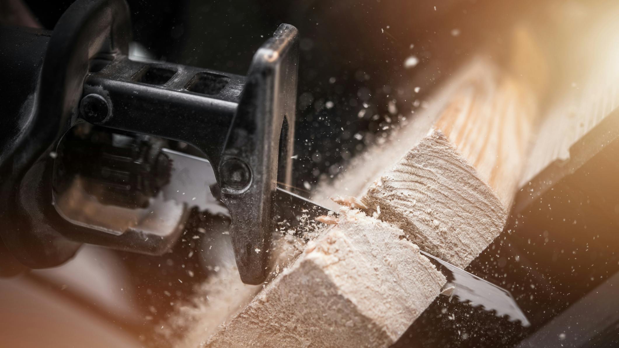 Reciprocating Saw Wood Work. Reciprocating Saw in Action Closeup Photo. Power Tool Wood Cutting Construction Theme.