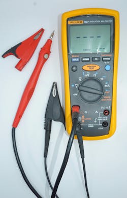 Photo 4. Insulation resistance testers with additional features are often used in periodic maintenance applications because of increased features. At the push of the appropriate button, some will automatically perform and measure dielectric absorption ratio and polarization index. The red lead on this tester has a gray push button to allow applying test voltage without having to initiate the test from the meter itself. Photo 4. Insulation resistance testers with additional features are often used in periodic maintenance applications because of increased features. At the push of the appropriate button, some will automatically perform and measure dielectric absorption ratio and polarization index. The red lead on this tester has a gray push button to allow applying test voltage without having to initiate the test from the meter itself.