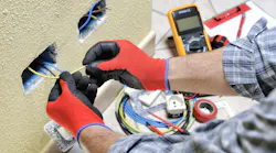 Electrician technician at work with safety equipment on a residential electrical system. Electrician technician at work prepares the cable with hands protected by gloves in a residential electrical installation Electrician technician at work with safety equipment on a residential electrical system. Electrician technician at work prepares the cable with hands protected by gloves in a residential electrical installation