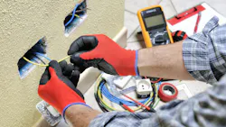 Electrician technician at work with safety equipment on a residential electrical system. Electrician technician at work prepares the cable with hands protected by gloves in a residential electrical installation Electrician technician at work with safety equipment on a residential electrical system. Electrician technician at work prepares the cable with hands protected by gloves in a residential electrical installation