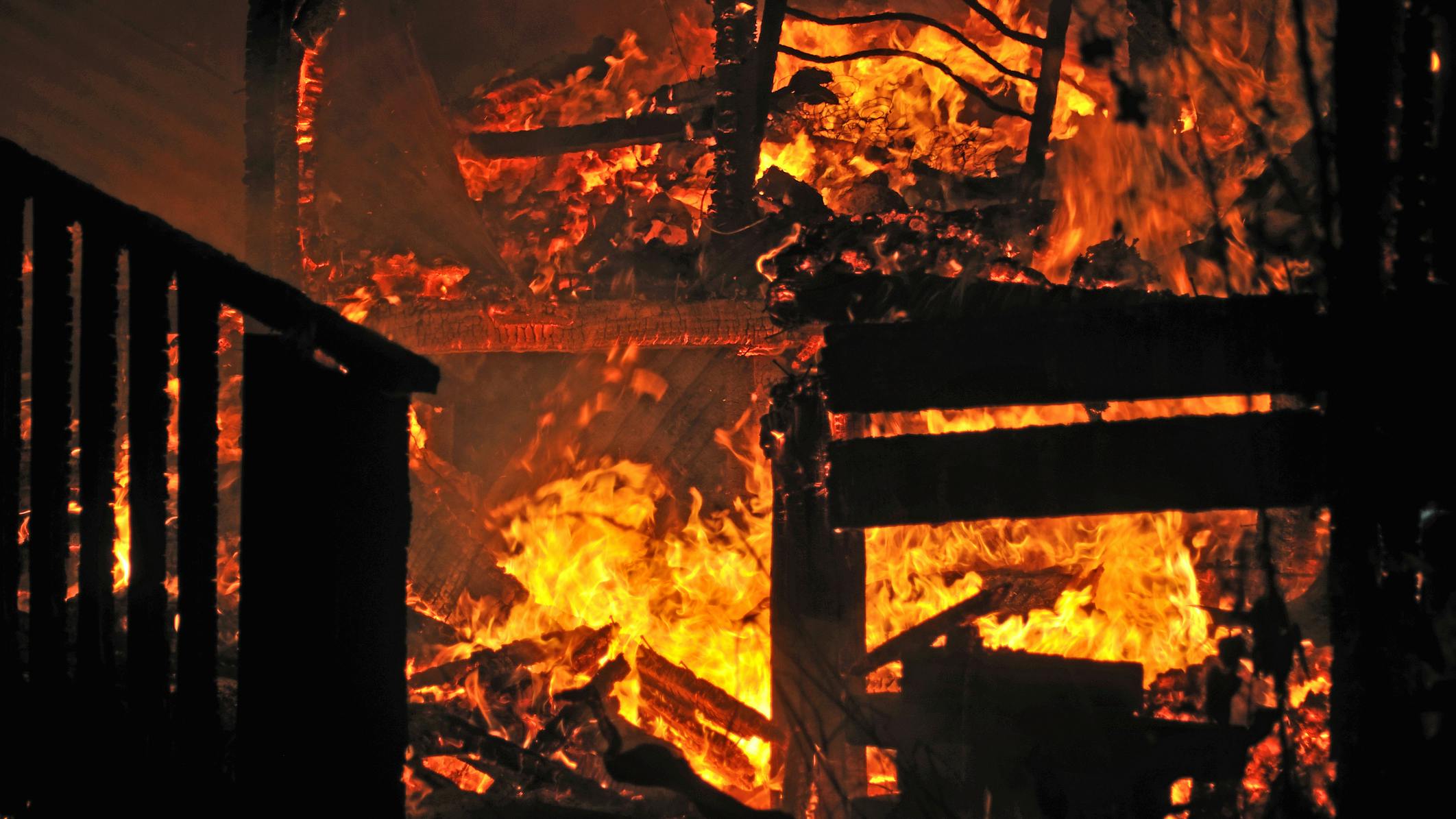 House on fire. Stairs and bedroom furniture silhouetted in house fire
