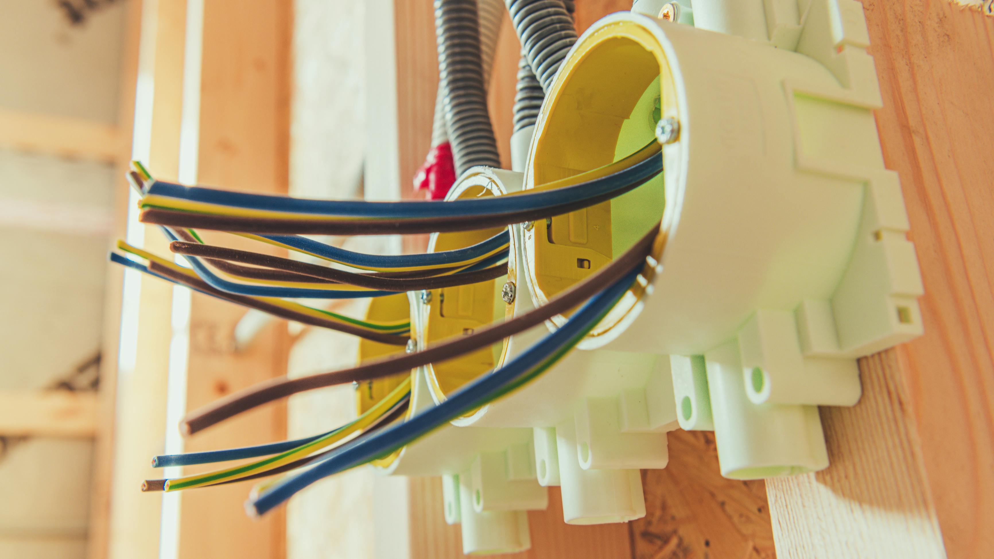 Electrical Wires and Installations in a Residential Construction Project. Electric wires are organized in junction boxes as part of home wiring during a construction project. This process ensures safety and efficiency in electrical systems