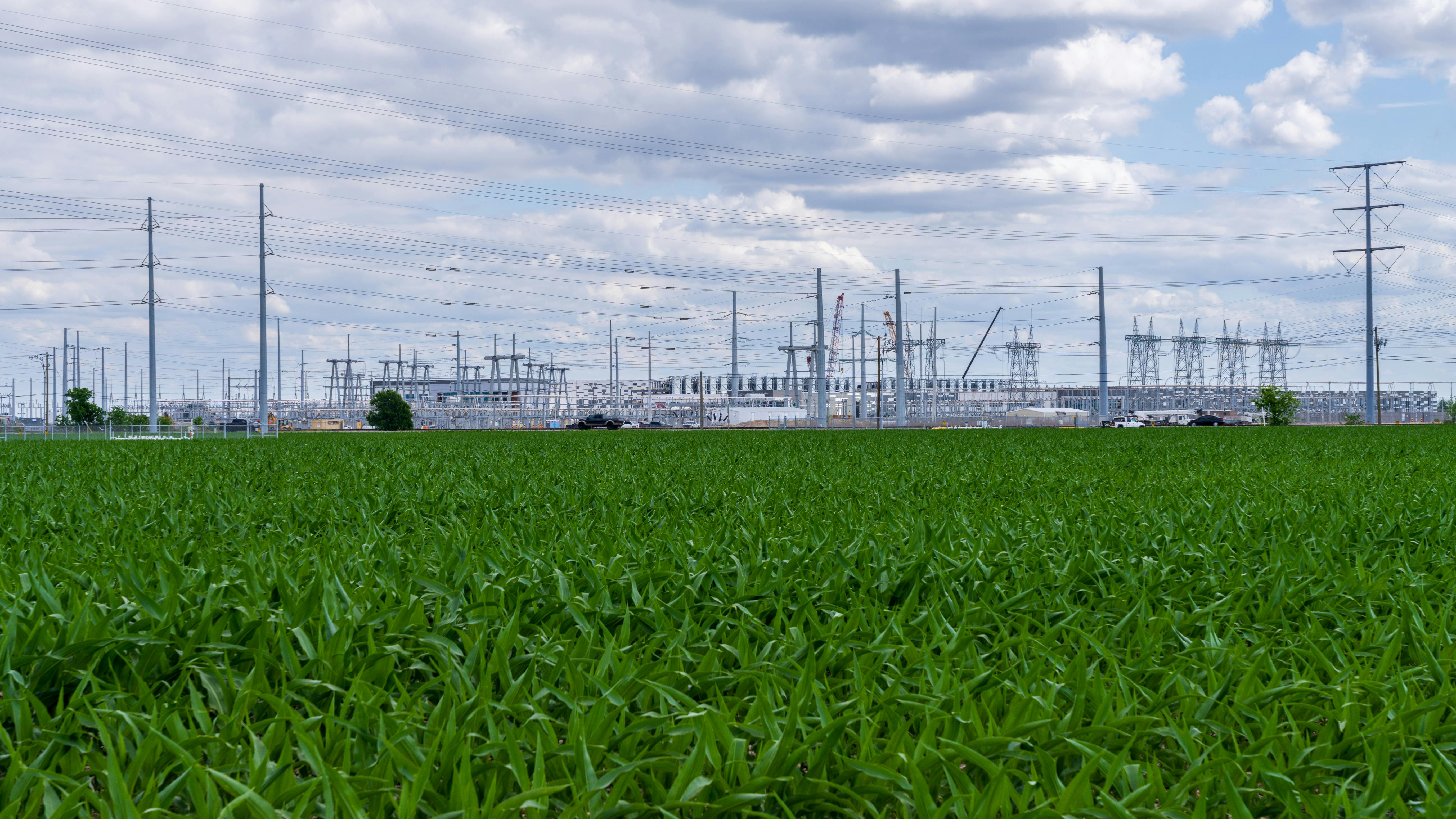 Construction of the 600 MW power facility at a new data center in Hutto Texas shows the rural landscape and sprawling corn fields.