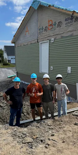 From left to right: Dr. Michael Catalano, licensed master electrician and school counselor; Anthony Bertorelli; David Hemsworth; and Daniel Salazar pose after installing the underground electrical service at an Ulster County Habitat for Humanity home. Under supervision, the students installed 4/0-4/0-2/0 aluminum underground residential distribution (URD) cable from the pad-mounted transformer to the outdoor load center using 2-inch Schedule 40 and Schedule 80 PVC conduit, with rigid metal conduit beneath the driveway for additional mechanical protection.