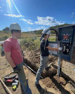 From left to right: Samuel Drake and Sean Secor, both 2024 graduates of the Ulster BOCES Electrical Construction and Maintenance program, install a temporary electrical service for an Ulster County Habitat for Humanity home. Working under supervision, they learned how to install a temporary power distribution system supplied from a nearby pad-mounted transformer, providing safe and reliable 120V and 240V power for construction activities. Replacing portable generators with temporary utility power improved safety and efficiency while giving the students valuable hands-on experience with temporary services, service equipment, and code-compliant electrical installations. Projects like this prepare the next generation of electricians while helping build affordable homes for local families.