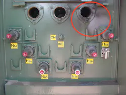 Photo 5. This distribution transformer was taken out of service and replaced due to an overheating issue (inside the red circle). The costly replacement and downtime could have been avoided using predictive maintenance technologies, such as infrared thermography. The overheating issue may have been identified before the temperature rise problem became visible and an expensive replacement was installed. In this case, a thermal imaging camera was on hand, but the organization had failed to implement an electrical maintenance program, thus never surveying the equipment.
