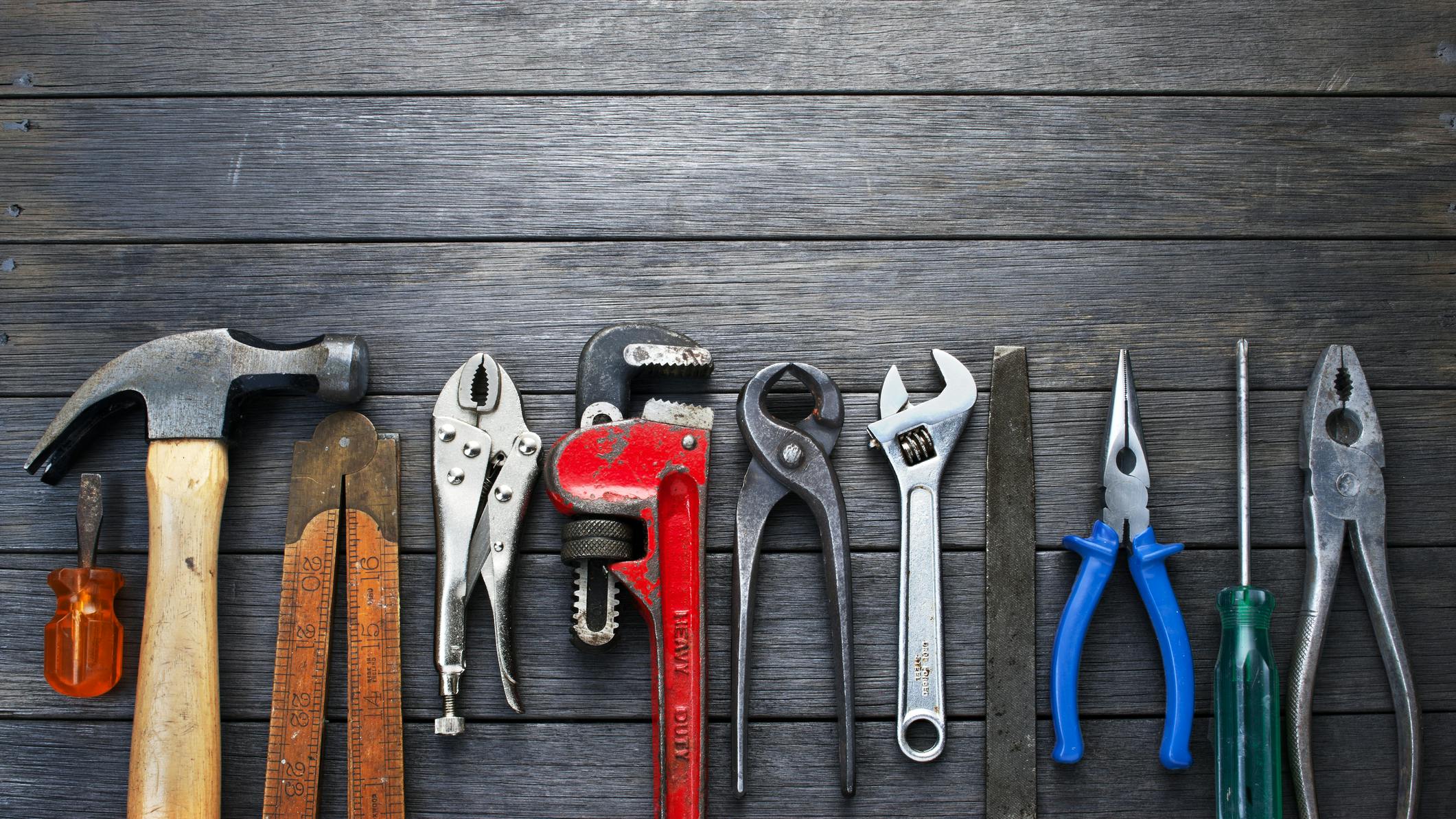 Tools Rustic Wood Background Business Construction. A still-life of tools on a rustic wood background.