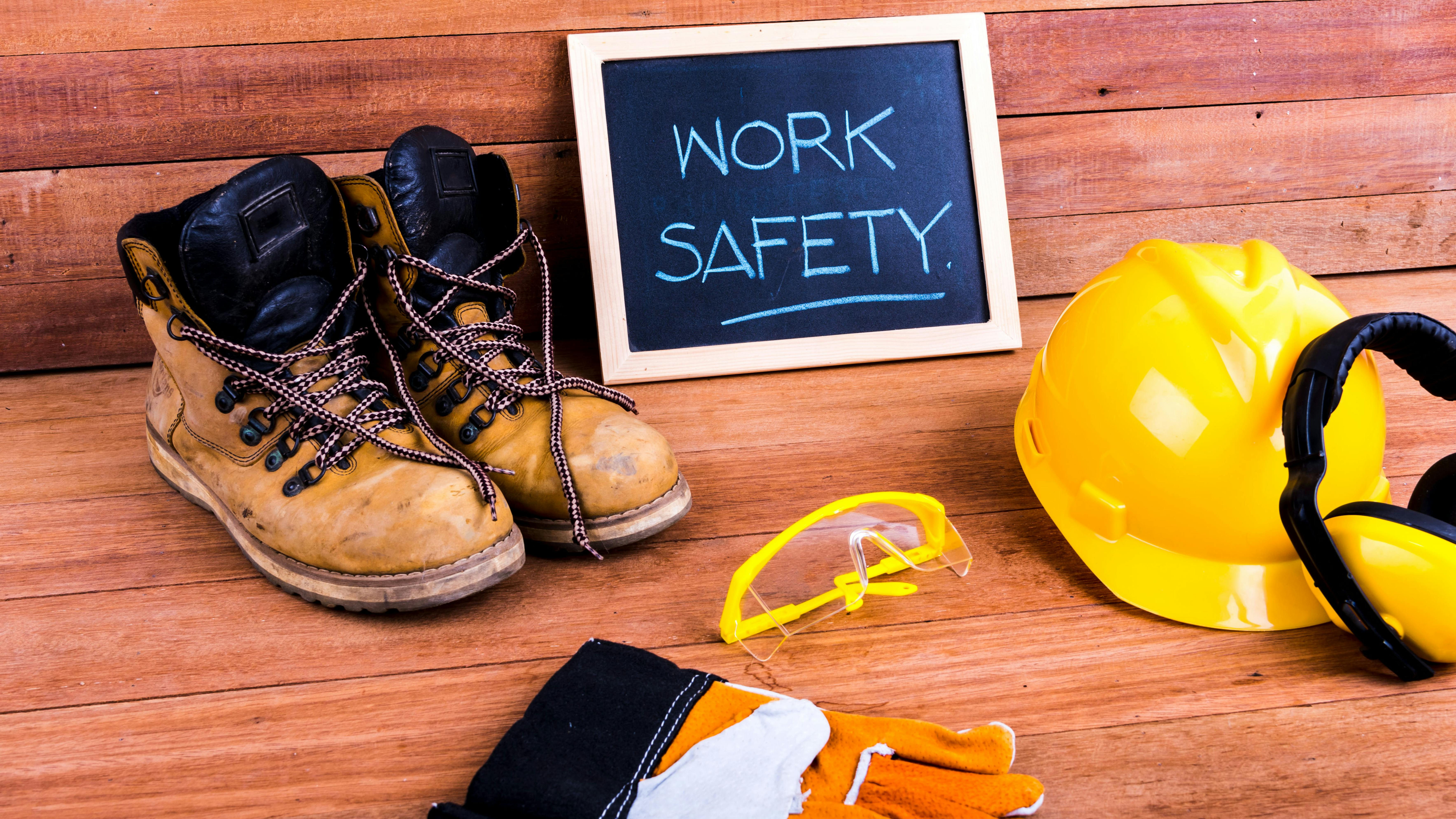 Safety first. Standard construction safety equipment on wood background