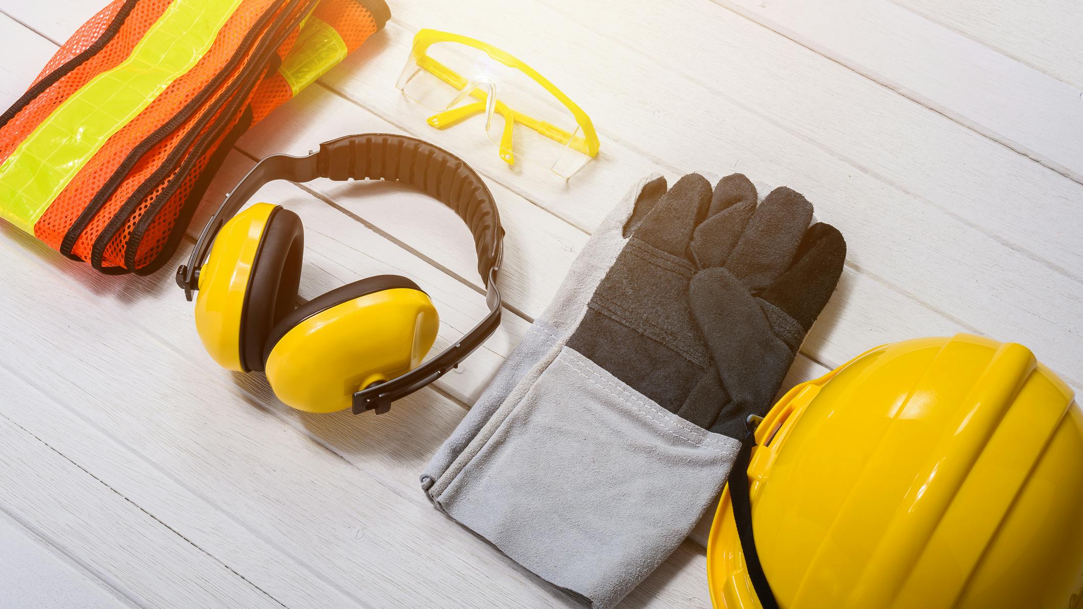Standard construction safety equipment on wooden table. Standard construction safety equipment on white wooden background. safety first concepts