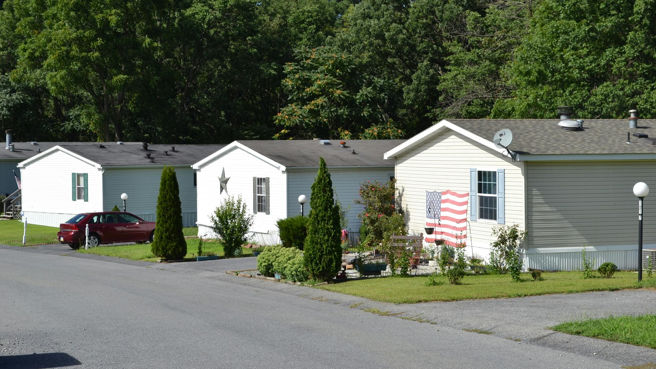 Mobile Home park. Park of mobile home community shown on this pictures. Three double wide trailers with one american flag on it