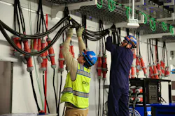 A Gaylor Electric employee routes server whip connections as part of an innovative load bank testing process at a data center job site in Atlanta. The company’s custom “whip cart” solution helps accelerate commissioning by testing power systems in stages before servers are fully operational.