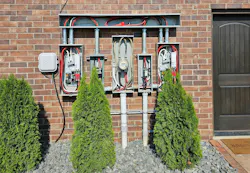 Photo 2. Beginning at the meter, this installation has service conductors that go left and right into transfer switches on either side of the meter. These transfer switches are the service equipment, as can be seen by the main bonding jumpers in each. The service conductors pass through a cutout box that is not the service equipment. This practice is now a violation of this Section.