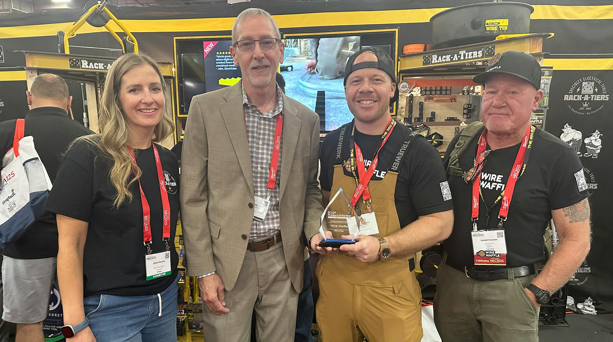 Mike Eby, VP of Content Strategy for the Buildings and Construction Group, presents Rack-A-Tiers with EC&amp;M's 2026 Product of the Year overall Platinum award for its Wire Waffle at the NECA 2026 show. Pictured from left are: Allison Menzies, Rack-A-Tiers; Mike Eby, EC&amp;M; Hunter Franssen, Wire Waffle; and Randall Franssen, Franssen's Electric.
