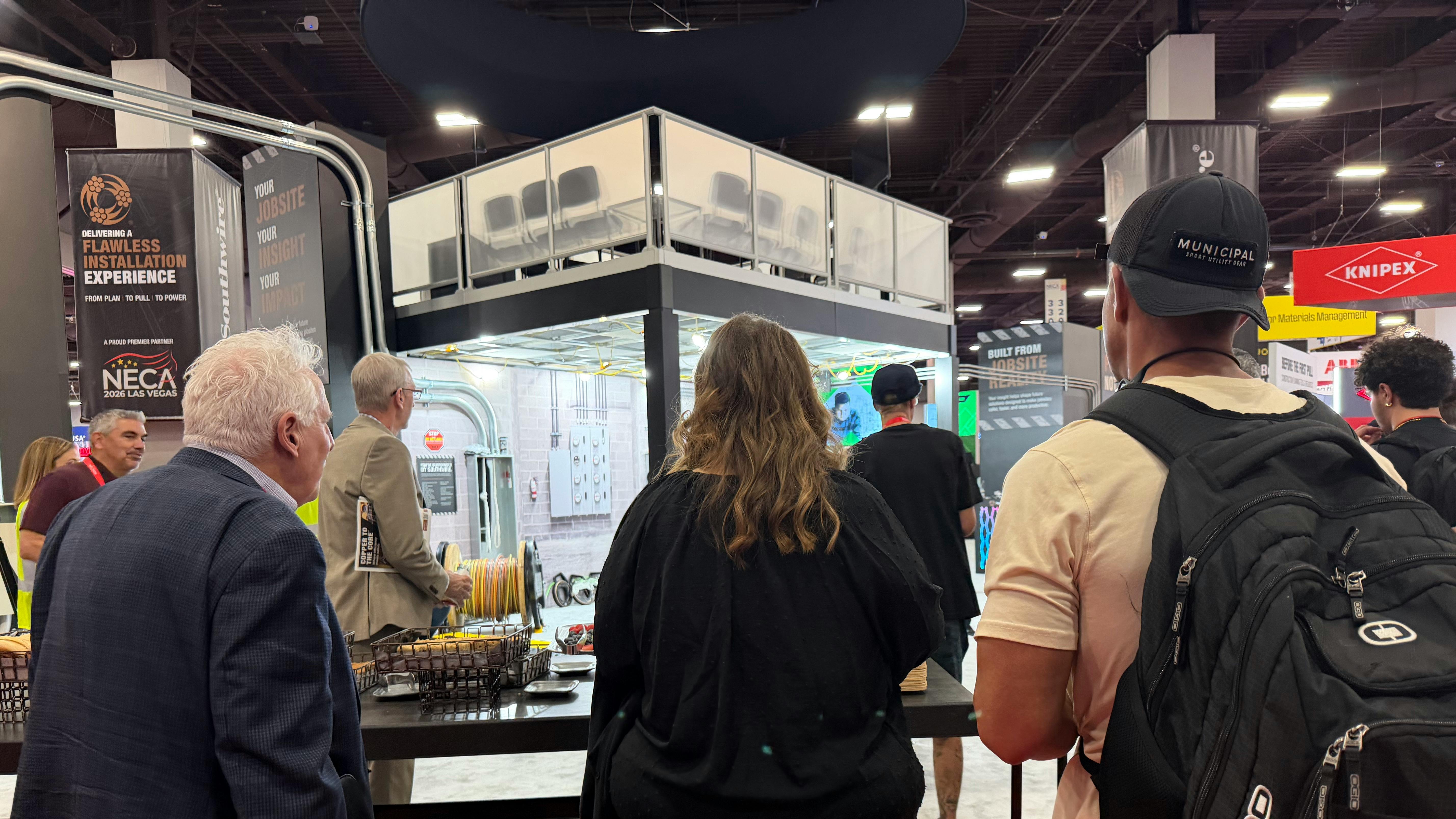 From left to right: Electrical Wholesaling Editor-in-Chief Jim Lucy, EC&amp;M Editor-in-Chief Ellen Parson, and Trevor Ottmann, the Everyday Electrician, visit the Southwire booth.