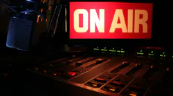 On-Air Radio Panel. On Air sign glowing, reflecting light on a radio studio broadcast panel.